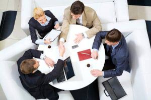 Business people sat around meeting table